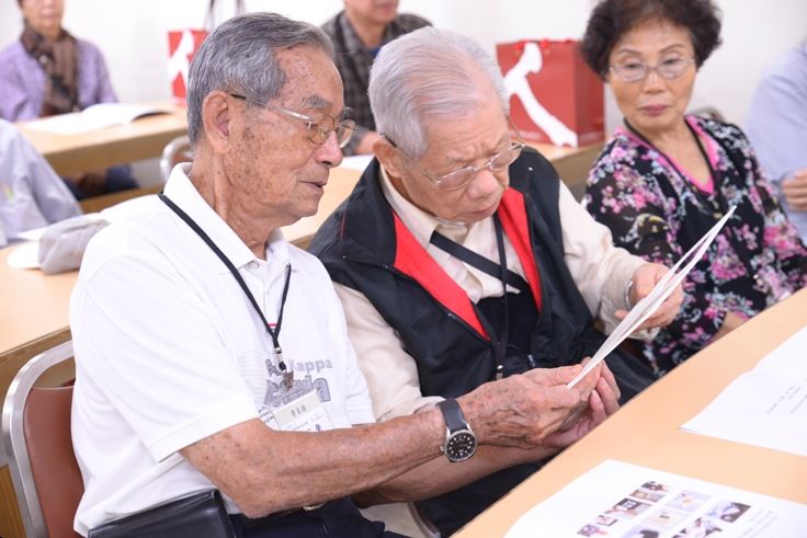 政治受難者吳昭榮與陳德祥前輩觀看保存照片的開窗夾裱措施