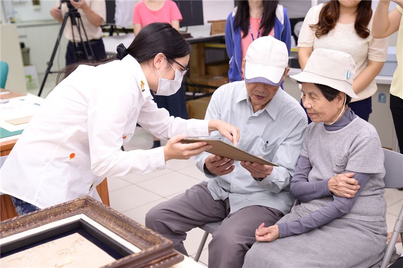 政治受難者陳文質與夫人近距離觀察捐贈的貝殼畫