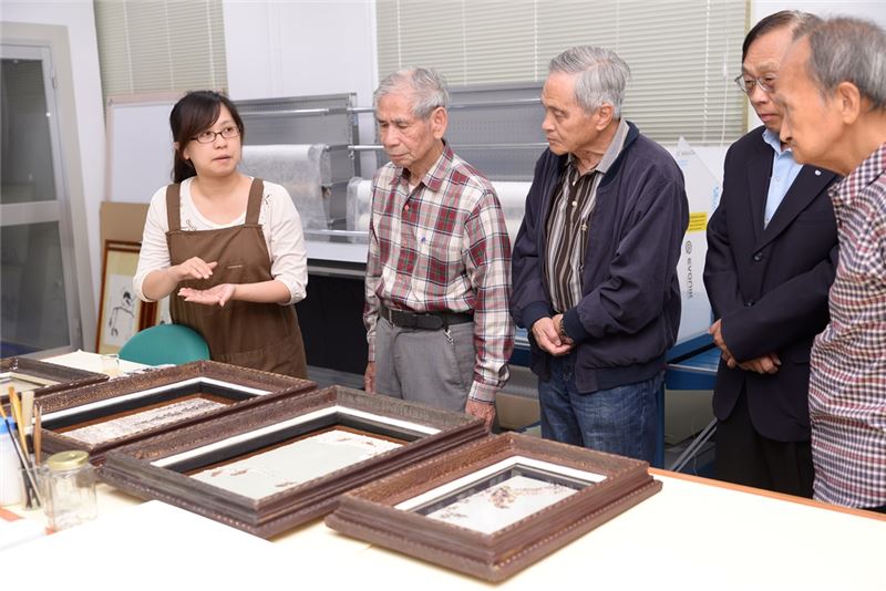 修復師為政治受難者前輩介紹貝殼畫修復作業