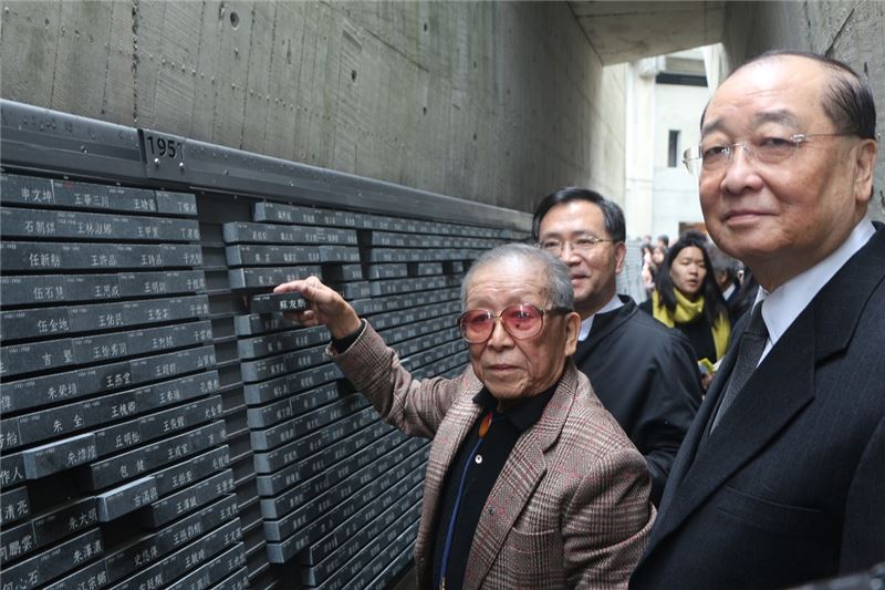 文化部長洪孟啟(右)、政務次長蔡炳坤,陪同受難者長輩蘇友鵬(左),將錄名碑石崁入紀念碑中。