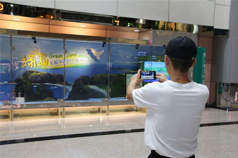 綠島人權故事文化櫥窗甫佈展竣工即吸引國際機場遊客拿手機捕捉自然人文風光