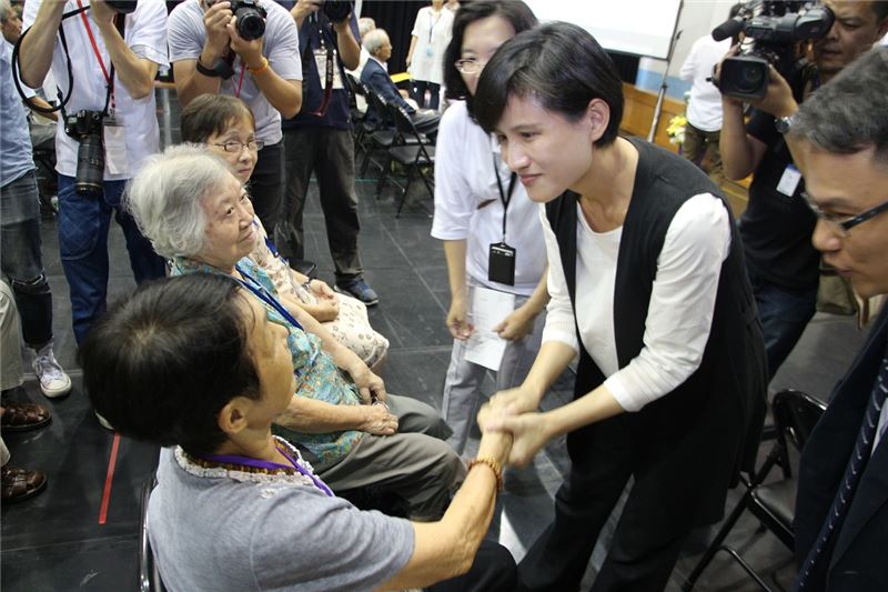 鄭麗君部長向受難者長輩張常美女士握手致意。