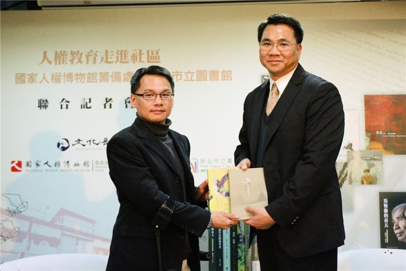 人權館主任王逸群贈送出版品予唐連成館長,象徵人權館出版品由新北市立圖書館進行典藏推廣