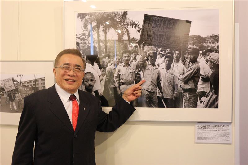 政治受難者陳中統醫師於展場中與展出的照片合影