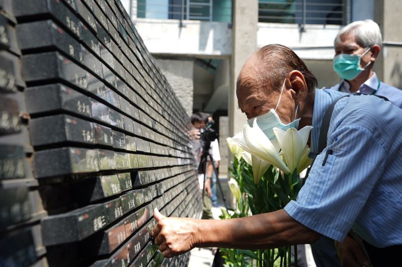 受難者家屬向紀念碑獻上百合