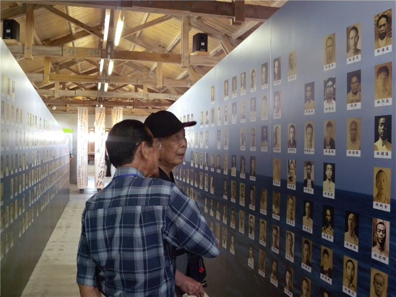 受難者林麗南(右)及劉德旺(左)在青春歲月受難者紀念牆上尋找自己及難友的名字及照片