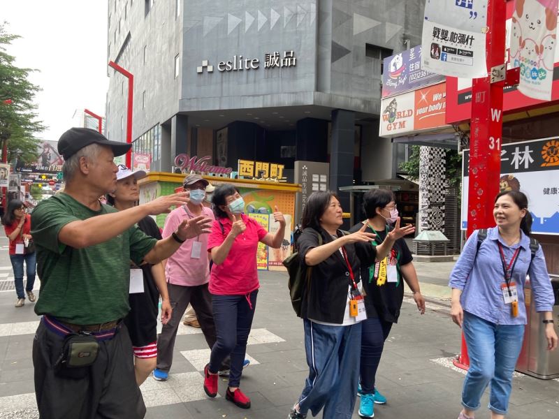 圖3_手語翻譯員丁立芬老師(右3)於西門町獅子林廣場,以手語解說東本願寺舊址裡的人權遭遇。