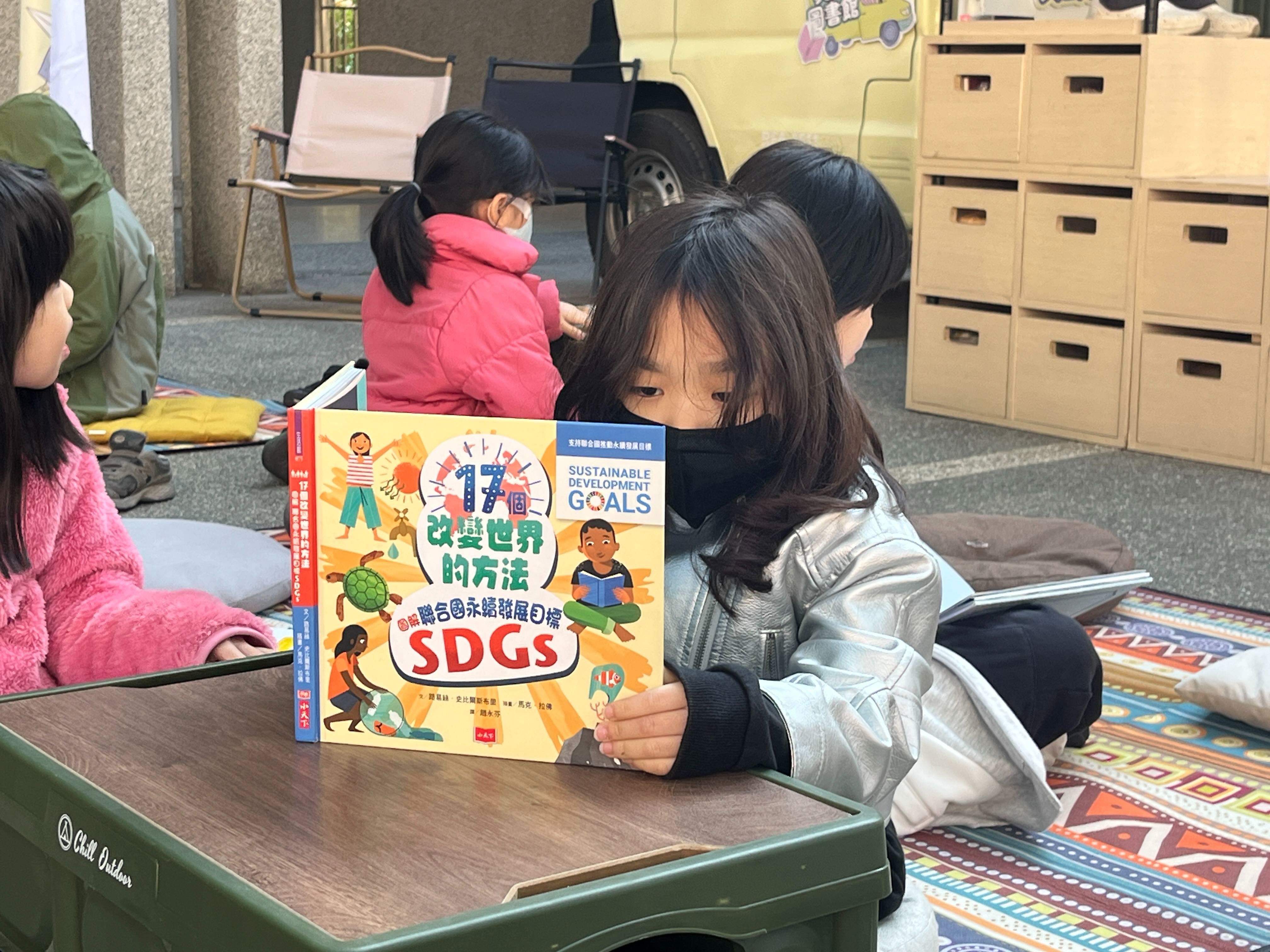 小朋友正透過繪本《17個改變世界的方法》認識聯合國永續發展目標SDGs的內容。