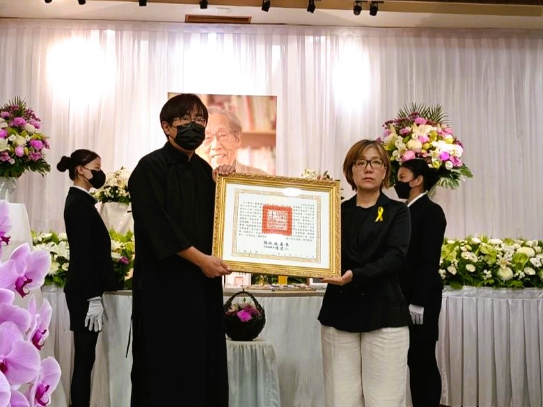 文化部政務次長王時思（右）代表頒贈總統褒揚令，由蔡焜霖長子蔡炎龍（左）代表受贈。