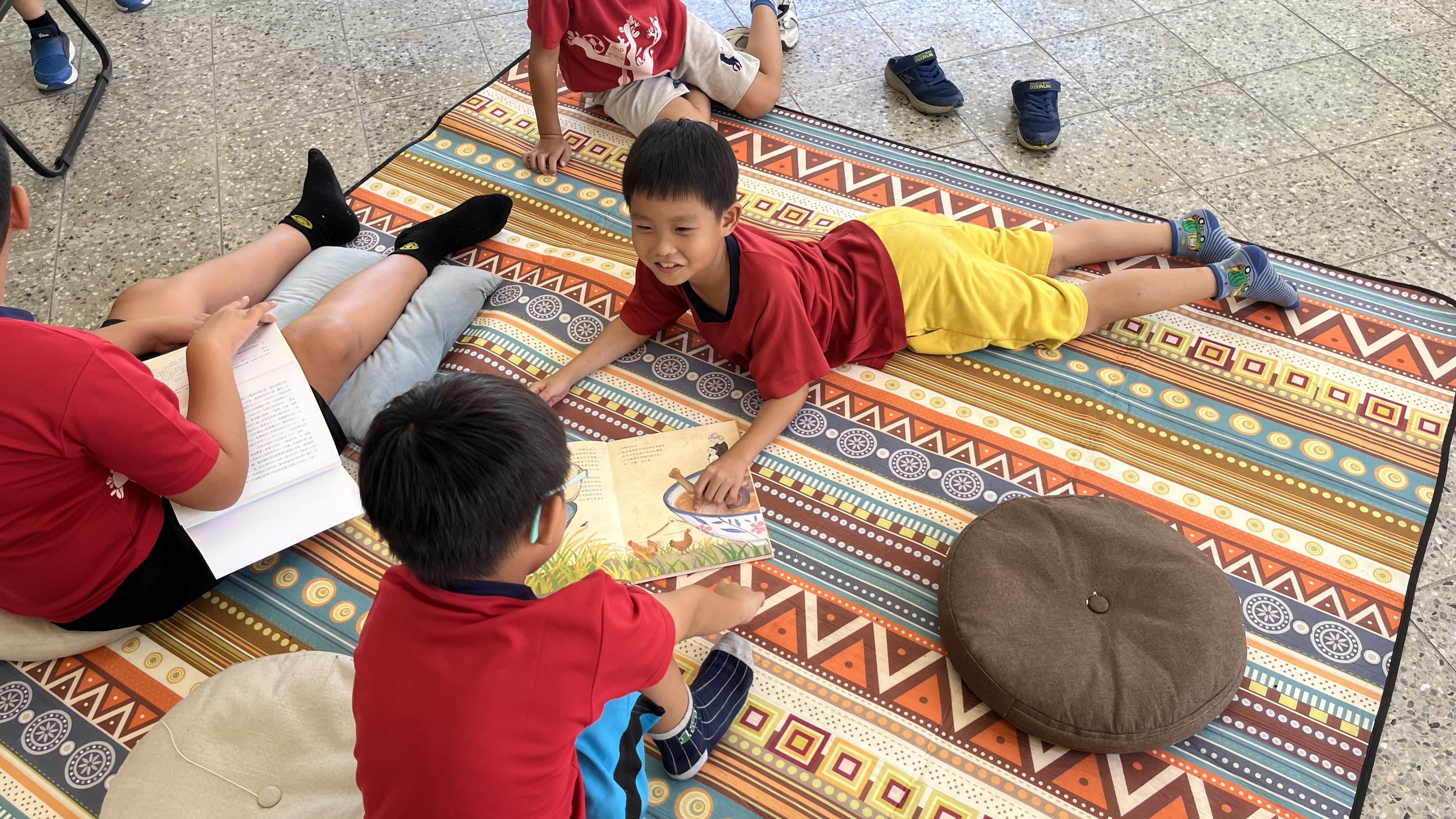 花蓮東里國小同學輕鬆悠閒在野餐墊上聊著書中內容